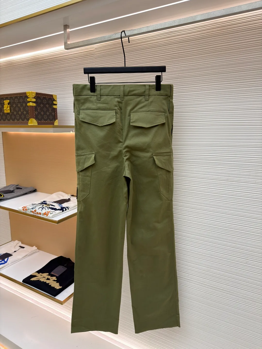 LOUIS VUITTON portrait embroidered work trousers ●Item number: 1681219-B65 ●Material: cotton twill fabric ●Technology: embroidery production ●Color: green ●Version: fitted version ●Weight: about 655 grams ●Size: 44-46-48-50 ●Description: The high cotton content ensures the fabric's excellent breathability, durability and classic workwear texture, while the twill weave gives it unique wear resistance and stiffness. The special fabric technology solves the pain points of tight and stiff traditional overalls; it provides greater freedom when moving, significantly improves wearing comfort and flexibility, and achieves a balance between function and comfort. For the embroidered portrait patch on the left, the portrait is digitally processed and converted into a line drawing blueprint that can be embroidered. A high-precision computer embroidery machine is used to perform multi-layer embroidery, and the outline, light and shade and texture details of the portrait are created by interweaving and superimposing embroidery threads of different colors. Tens of thousands of stitches and fine color transitions ensure clear lines and no unnecessary threads, making the portrait lifelike and three-dimensional. The design of the trousers combines retro workwear genes with modern deconstruction. The core lies in the neat pleat processing, which not only deconstructs the flat silhouette of the front, increases the three-dimensional sense and design level, but also visually optimizes the leg lines. Multiple flap pockets are classic workwear functional elements and the overall tough style. The overall wiring is straight and delicate, the fabric is comfortable and soft, and the color is consistent without color difference. It can be matched with the same style to create a fashionable look and control various occasions. Customized accessories, complete with three standards, same style for men and women!